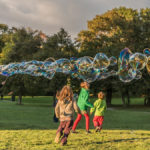 spielende Kinder mit Riesen - Seifenblasen im Englischen Garten in München