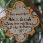 Grabkreuz mit der Inschrift "hier ruht in Gott Adam Lentsch, 26 Jahre lebte er als Mensch und 37 Jahr als Ehemann"