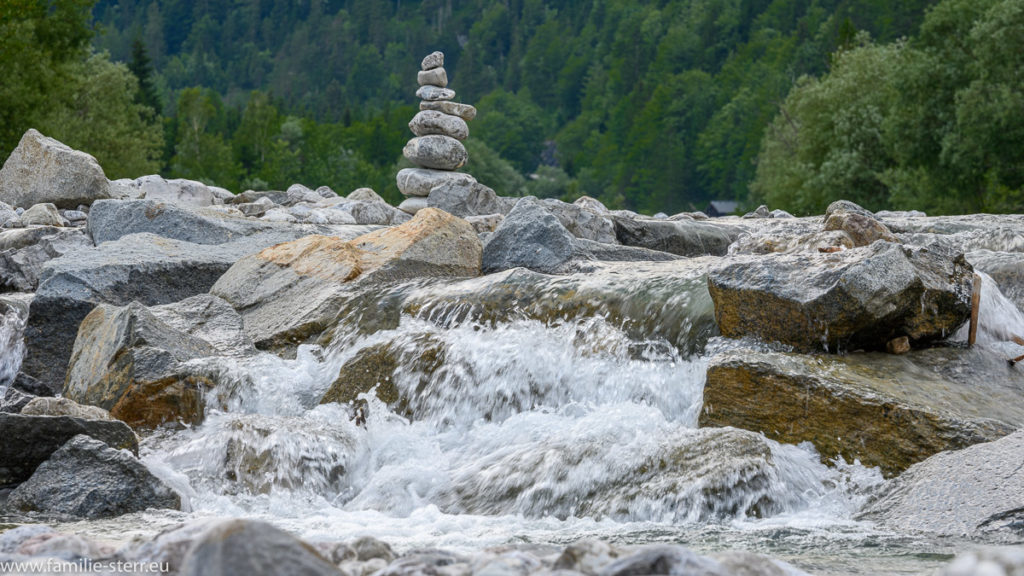 Steinmännchen an der Isar bei Lenggries mit kleinem Wasserfall davor