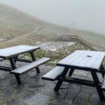 schneebedeckte Tische auf der Terrasse der Rudolfshütte beim Weißsee im Salzburger Land