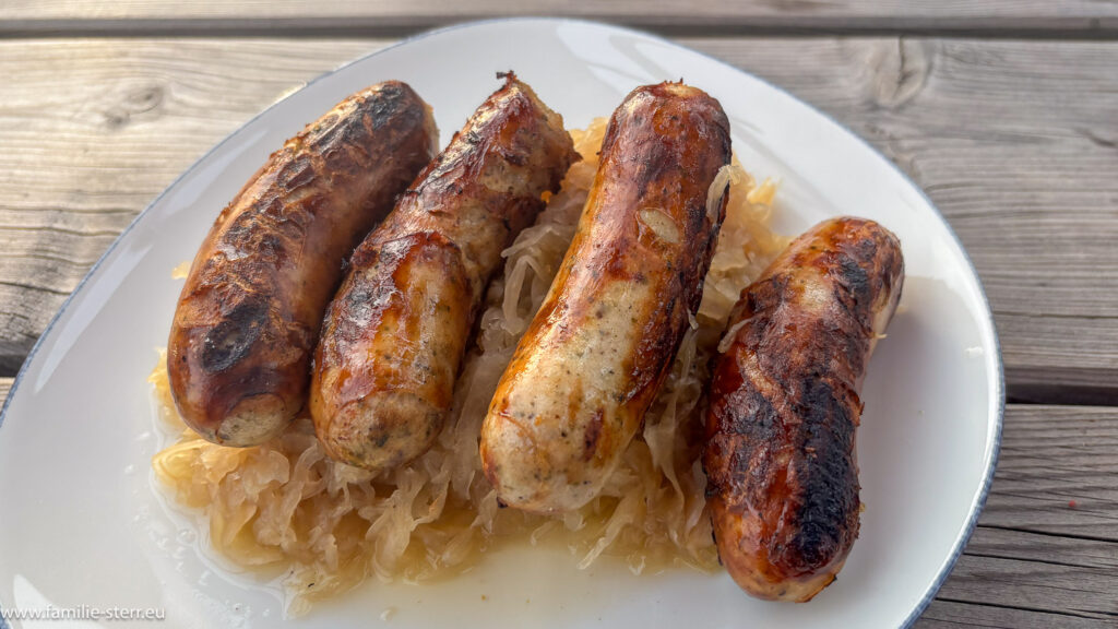 zwei paar Schweinswürstel mit Kraut im Kämper - Biergarten in Wang bei Moosburg an der Isar