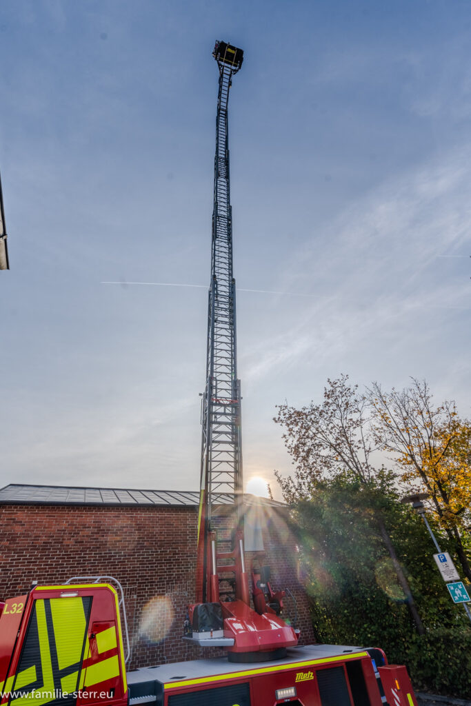 die 30Meter - Leiter der freiwilligen Feuerwehr Hallbergmoos ragt auf in den vorabendeichen Himmel über der Gemeinde